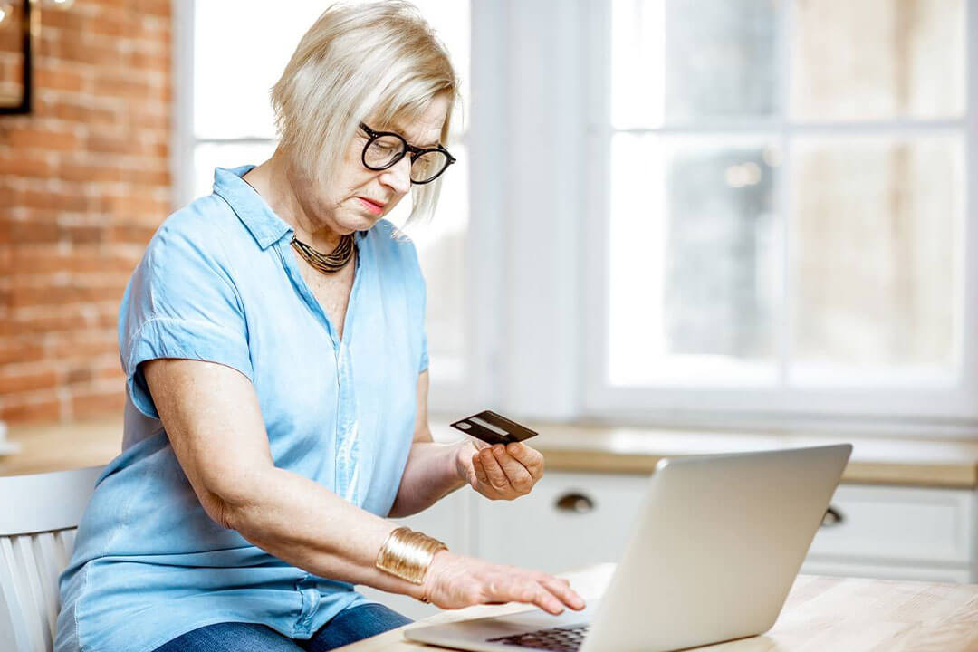 Lady using her debit card to shop online.